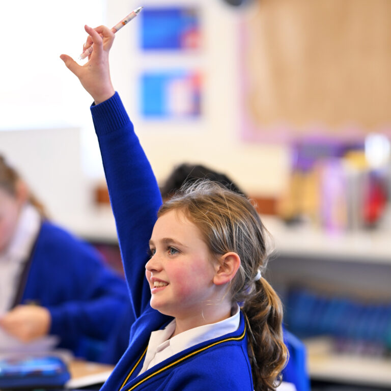 Queen's College Prep pupil raising hand in class