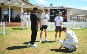 Former professional cricketer Arul Suppiah interacts with Queen's pupils during a cricket match.
