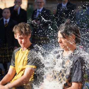 Two sixth form boys getting soaking wet in a soak the pupil challenge 