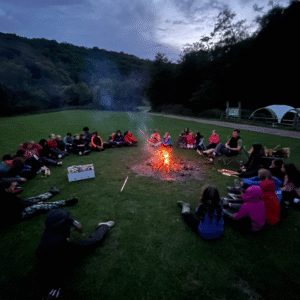 Pupils sitting around a fire.