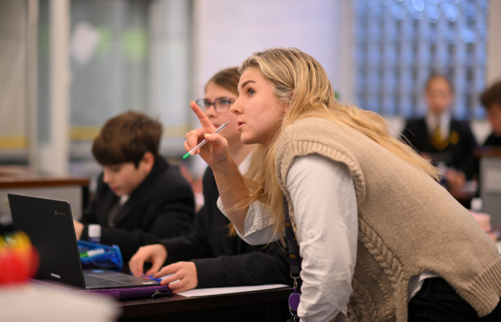 Queen's College teacher helping a pupil
