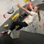 A girl on a climbing wall.