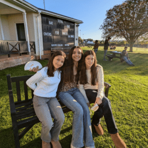 3 girls sat on a bench.
