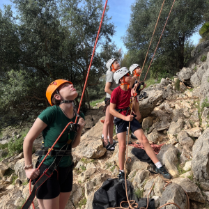 4 pupils preparing to climb a rock. 