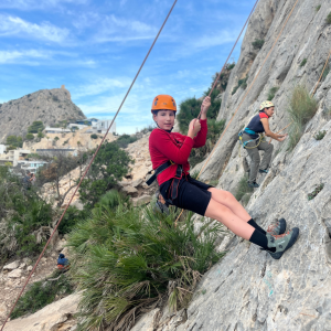 2 girls climbing a rock.