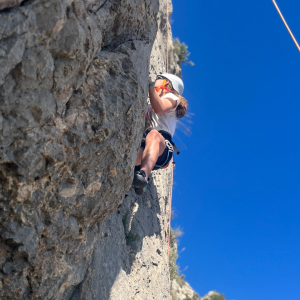One girl climbing a high rock.
